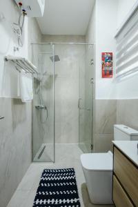 ein Badezimmer mit Glasdusche und Toilette in der Unterkunft The Avery at Lapwing Place in Accra