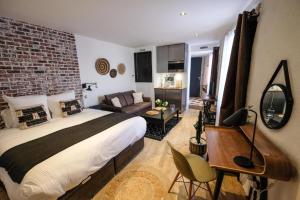 a bedroom with a bed and a brick wall at Demeure Terrisse Les Studios in Marseillan