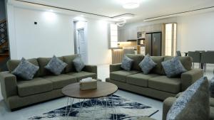 a living room with two couches and a table at Villa Dalia Puncak Na5-06 in Cikundul