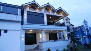 a white house with lights on top of it at Villa Dalia Puncak Na5-06 in Cikundul
