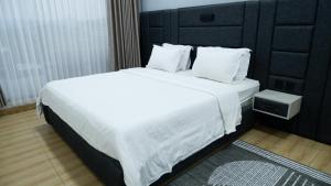 a bedroom with a large bed with white sheets and pillows at Villa Dalia Puncak Na5-06 in Cikundul