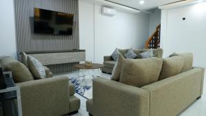 a living room with two couches and a tv at Villa Dalia Puncak Na5-06 in Cikundul