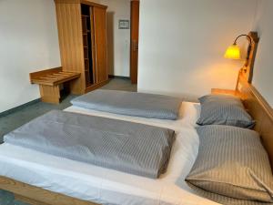 two twin beds in a room with a lamp at Fichtelgebirgshof in Himmelkron +3 photos