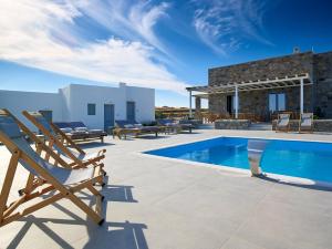 een villa met een zwembad en 2 stoelen bij Lithos Luxury Rooms (Adults Only) in Adamas
