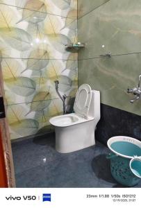 a bathroom with a toilet and a wall at JOHNs' Paradise - Homestay in Cochin +11 photos