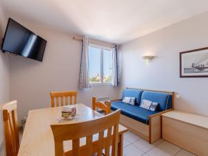 a living room with a blue couch and a table at L Ocean N40 2P5 in La Tranche-sur-Mer