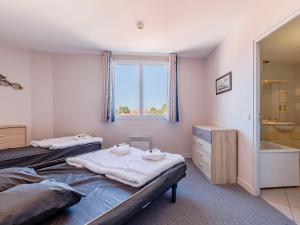 a bedroom with two beds and a window and a tub at L Ocean N40 2P5 in La Tranche-sur-Mer