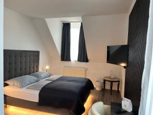 a bedroom with a bed and a flat screen tv at Fichtelgebirgshof in Himmelkron