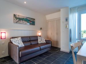a living room with a brown leather couch in a room at Sud Ocean M N105 2P5 in Guidel
