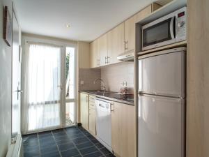 a kitchen with a refrigerator and a microwave at Sud Ocean M N105 2P5 in Guidel