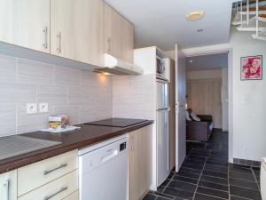 a kitchen with white cabinets and a black tile floor at Sud Ocean M N105 2P5 in Guidel +12 photos