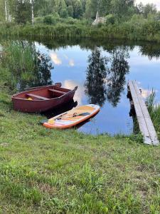 a boat sitting on the side of a lake at namelis tyloje in Šarkiškės