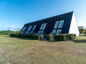 a black and white building with bushes in front of it at Sud Ocean M N105 2P5 in Guidel