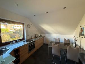 eine Küche mit Spüle und Tisch mit Stühlen in der Unterkunft Ferienwohnung Romy in Ersen in Liebenau