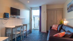 a living room with a couch and a table at Sud Ocean L N94 2P4 in Guidel
