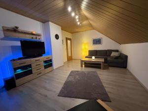 ein Wohnzimmer mit Sofa und Flachbildfernseher in der Unterkunft Ferienwohnung Romy in Ersen in Liebenau