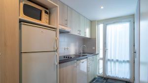 a kitchen with a refrigerator and a sink at Sud Ocean L N94 2P4 in Guidel