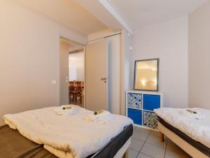 a bedroom with two beds and a mirror at L Ocean N08 3P5 in La Tranche-sur-Mer