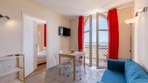 a living room with a blue couch and a view of the ocean at L Ocean N36 2P2 in La Tranche-sur-Mer