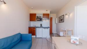 a living room with a blue couch and a kitchen at L Ocean N36 2P2 in La Tranche-sur-Mer