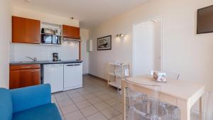 a kitchen with a table and a dining room at L Ocean N36 2P2 in La Tranche-sur-Mer
