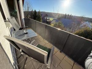 eine Terrasse mit Tisch und Stühlen auf einem Balkon in der Unterkunft Ferienwohnung Romy in Ersen in Liebenau