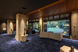 een lobby met banken, tafels en ramen bij 嬉野温泉 枯淡嬉野 in Ureshino