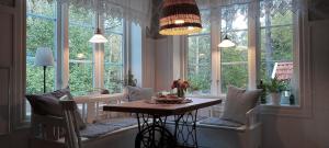 a dining room with a table and some windows at Lilla Skogstorp in Åseda