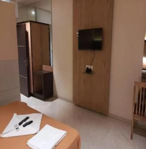 a room with a table and a tv and a door at M B Residency Lodging and Boarding in Badlapur