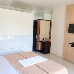 a room with a bed and a bathroom with a mirror at M B Residency Lodging and Boarding in Badlapur
