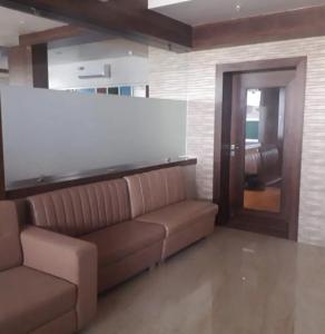 a living room with a brown couch in a room at M B Residency Lodging and Boarding in Badlapur