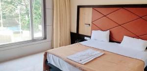a bedroom with a bed with a large window at M B Residency Lodging and Boarding in Badlapur