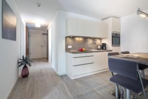 a kitchen with white cabinets and a counter top at Wohnart - Fewo 8 Wohnambiente in Norderney