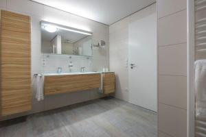 a bathroom with a sink and a mirror at Wohnart - Fewo 8 Wohnambiente in Norderney +3 photos