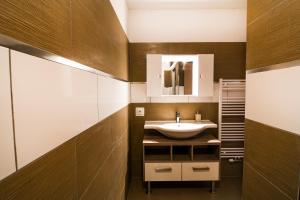 ein Bad mit einem Waschbecken und einem Spiegel in der Unterkunft Oscar & Sons Apartments in Piesendorf
