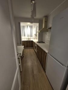 una cucina con frigorifero bianco e pavimenti in legno di Alpasio Rentals 3 a Galaţi