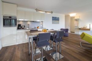 a kitchen with a table and chairs in a room at Wohnart - Fewo 6 Wohnkultur in Norderney +3 photos