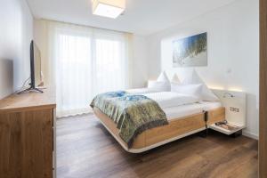 a bedroom with a bed and a television in it at Wohnart - Fewo 6 Wohnkultur in Norderney