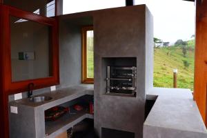 a bathroom with a sink and a mirror and a window at Aura dos Ipês in Paraisópolis
