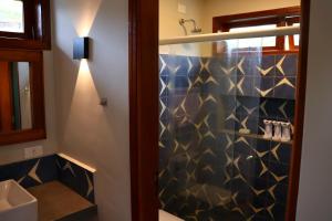 a bathroom with a shower with blue and gold tiles at Aura dos Ipês in Paraisópolis +23 photos