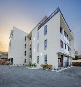 ein großes weißes Gebäude mit einem Parkplatz in der Unterkunft The Avery at Lapwing Place in Accra