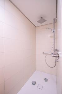 a white bathroom with a shower and a sink at Traumwohnung in Norderney +7 photos