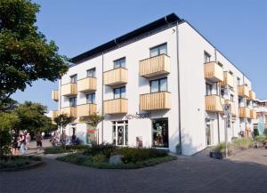 a white building with balconies on the side of it at Traumwohnung in Norderney