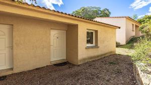 a house with two white doors and a window at Lisa Maria D N38 2P5 in Sari Solenzara