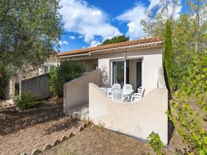 a villa with a fence and chairs in a yard at Lisa Maria E N60 3P7 in Sari Solenzara
