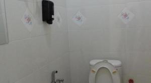 une salle de bain avec des toilettes avec des autocollants sur le mur dans l'établissement Sakiza View Mersing, à Mersing 57 autres photos