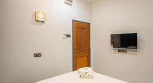 een kamer met een bed, een televisie en een deur bij Big Tree Boutique in Ipoh +31 foto's