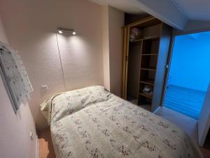 une chambre avec un lit avec une couverture et une fenêtre dans l'établissement la pinede de St georges, à Saint-Georges-de-Didonne