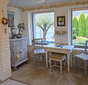 a room with a table and chairs and a window at Kristály Pihenőház in Szekszárd