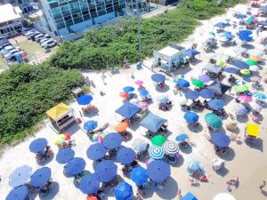 an overhead view of a beach with blue umbrellas at palmas beach in Governador Celso Ramos